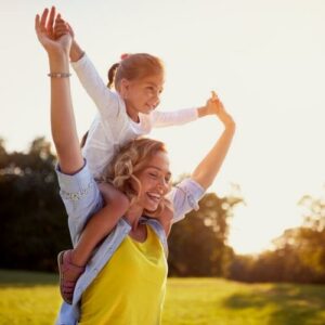 little girl happy on mom shoulders