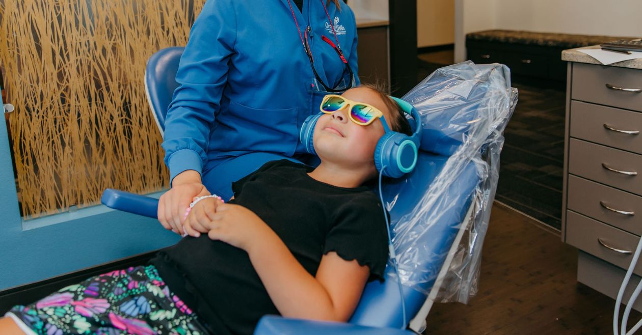 dental hygienist comforting a little girl at the dental office