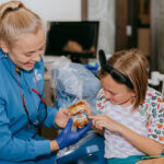 kid brushing teeth at dental office